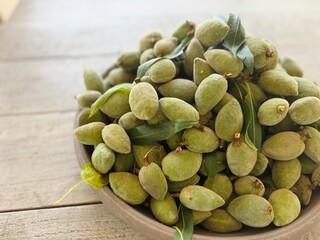 Freshly Harvested Almonds Piled on Tray on Wooden Table.
