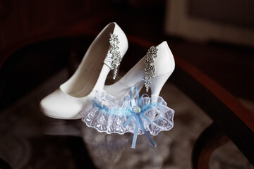 A pair of white shoes with a blue ribbon on them