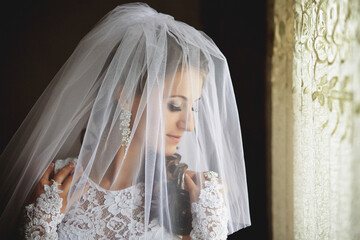 A woman in a wedding dress is wearing a veil that covers her face
