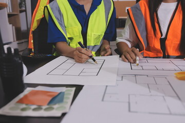 Closeup of team of industrial engineers meeting analyze machinery blueprints consult project on...