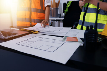 Closeup of team of industrial engineers meeting analyze machinery blueprints consult project on...
