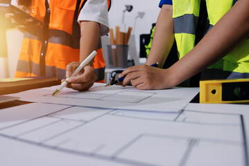 Closeup of team of industrial engineers meeting analyze machinery blueprints consult project on...