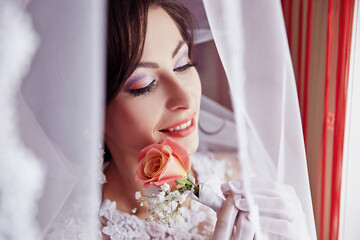 A woman is wearing a white dress and holding a rose