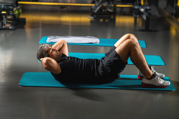 Man doing crunches in gym.
