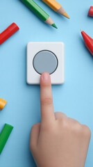 A young hand poised on a mystical button surrounded by vibrant pencils celebrates National Creativity Day and World Imagination Month