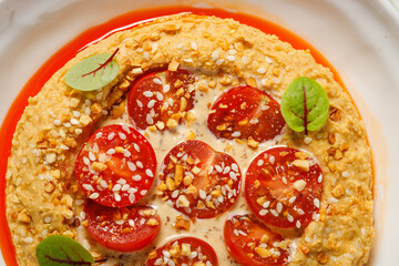 Delicious dish with tomatoes and sesame on a plate