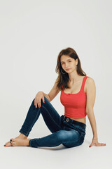 Teenager seated in casual attire, showcasing a relaxed and confident pose in a minimalistic studio