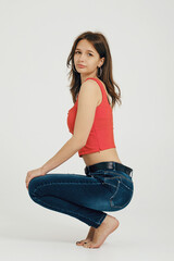 Teenager posing in casual attire, using a minimalist backdrop to highlight her style and confidence