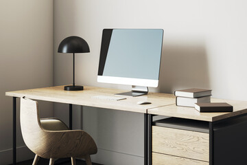 Modern minimalist home office workspace with wooden desk, computer display, black lamp, books, and cozy chair in corner interior room setup. 3D Rendering