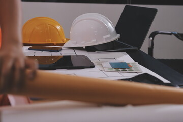 Closeup of team of industrial engineers meeting analyze machinery blueprints consult project on...