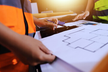 Closeup of team of industrial engineers meeting analyze machinery blueprints consult project on...
