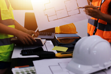 Closeup of team of industrial engineers meeting analyze machinery blueprints consult project on...