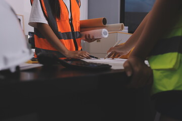 Closeup of team of industrial engineers meeting analyze machinery blueprints consult project on...