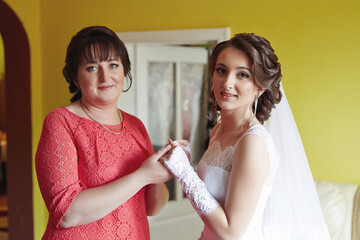 A woman in a red dress is holding a woman's hand