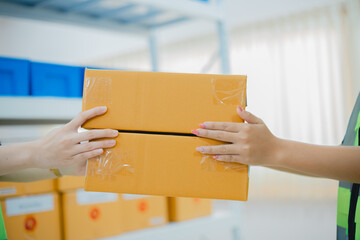 Home delivery service and working with a passion for service. A woman receives a cardboard box parcel from a shipping company.
