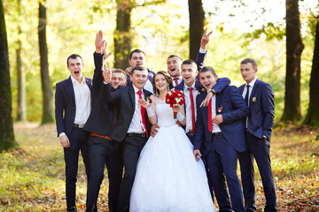 A group of men and a woman are posing for a picture in a forest