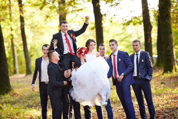 A group of men are posing for a picture with a bride