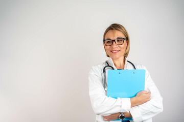 Smiling mature female doctor holding clipboard, isolated white background