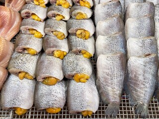 Sun dried snakeskin gourami fish with spawn in Thailand traditional local market, selective focus