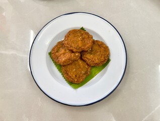 Fried Fish cake or fried fish-paste balls on white dish, selective focus. Popular Thai street food