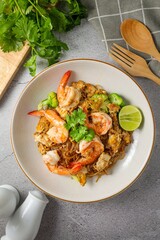 Stir-fried Thin Rice Noodles with dark Soy Sauce and shrimp in ceramic plate,