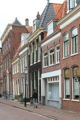 Grote Oost Street View with House Facades, Lamp Post and Walking Young Man in Hoorn, Netherlands