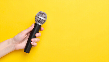 Hand Holding Microphone Over Yellow Background – Panoramic Mockup Image

