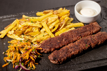 details of tasty meat kebabs with salad and fries