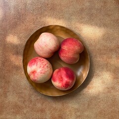 Four fresh peaches with pink - red hues are placed on a brown ceramic plate, set against a textured...