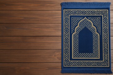 Top-down view of a Muslim prayer mat placed on a wooden surface with space for customization