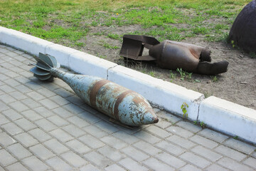 Mines from the Second World War lie on the ground next to the sidewalk. The mines are old and...