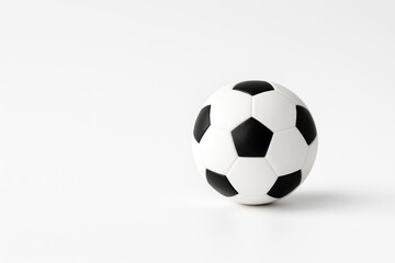 Fototapeta premium Small black and white soccer ball miniature with space-themed background