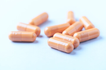 Calcium carbonate capsules. Bright paper background. Soft focus. Close up. Copy space.	