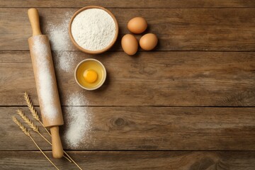 Baking essentials and ingredients arranged on a wooden surface, top-down view with space for message