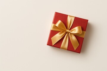 Festive gift container featuring red and gold hues, adorned with satin ribbon and bow against a soft pastel backdrop. Ideal for holiday, romantic, and New Year celebrations. Top-down flat lay with a