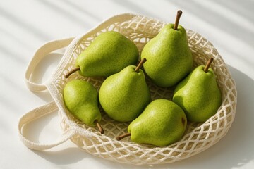 Fresh green pears in a lightweight cotton bag against a white backdrop during morning hours