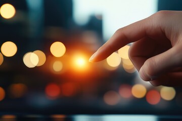 Hand pointing towards a bright light with blurred bokeh background