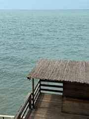 Wooden platform with a bamboo roof above the sea. Calm water and clear horizon. Usable for travel,...