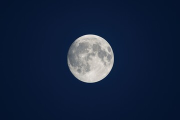Detailed shot of the full moon against a navy blue night sky