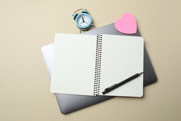 Top view of school supplies, pencils, erasers, paper clips and notebooks, on a beige background....