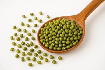 Fresh green mung beans displayed on a wooden spoon against a plain white backdrop