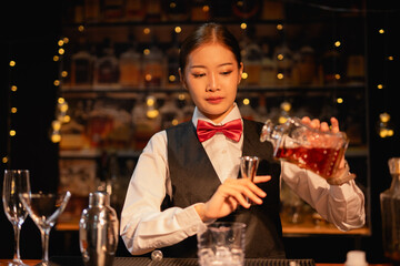  Professional female bartender preparing alcoholic drinks in a bar
