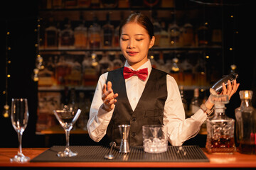 Professional female bartender preparing alcoholic drinks in a bar
