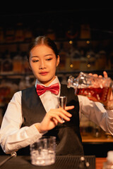 Professional female bartender preparing alcoholic drinks in a bar