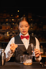 Professional female bartender preparing alcoholic drinks in a bar