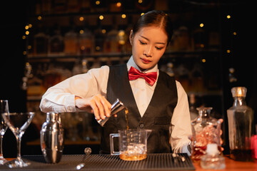  Professional female bartender preparing alcoholic drinks in a bar