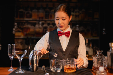 Professional female bartender preparing alcoholic drinks in a bar