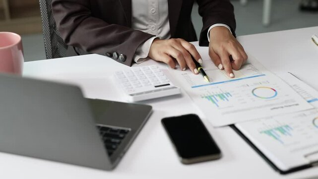 Business professional analyzing financial reports at office desk.
