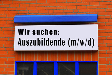 Aushang vor einer Firma mit der Aufschrift Wir suchen Auszubildende 