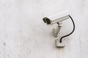 Security camera mounted on a weathered white wall